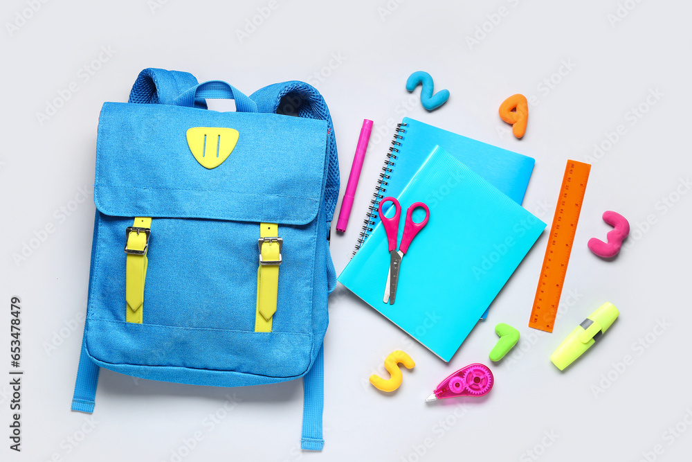 Stylish school backpack with different stationery on grey background