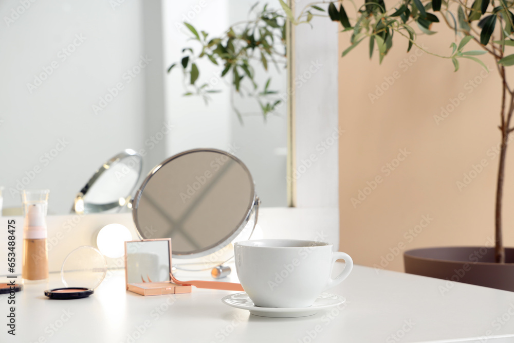 Cup with cosmetics on dressing table in makeup room, closeup