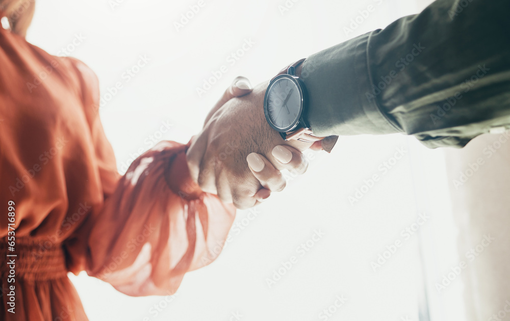 Creative people, handshake and partnership in meeting, b2b deal or teamwork below at office. Low angle of man and woman shaking hands for startup, introduction or thank you in agreement at workplace