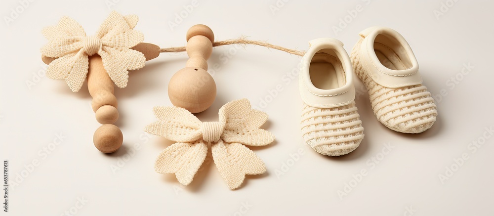 Neutral background with organic newborn gifts including baby shoes rattle and teether