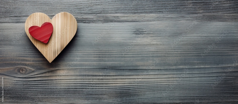 Christian cross with heart on gray wooden background