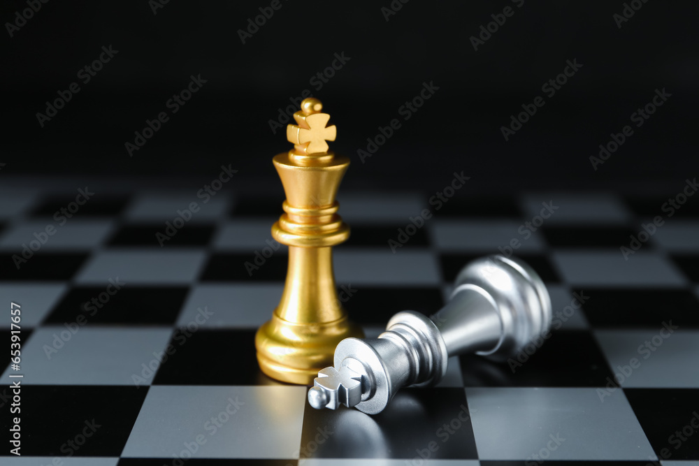 Board with chess pieces on dark background. Loser concept