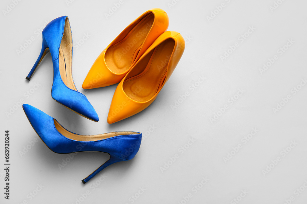 Stylish high heeled shoes on light background, top view