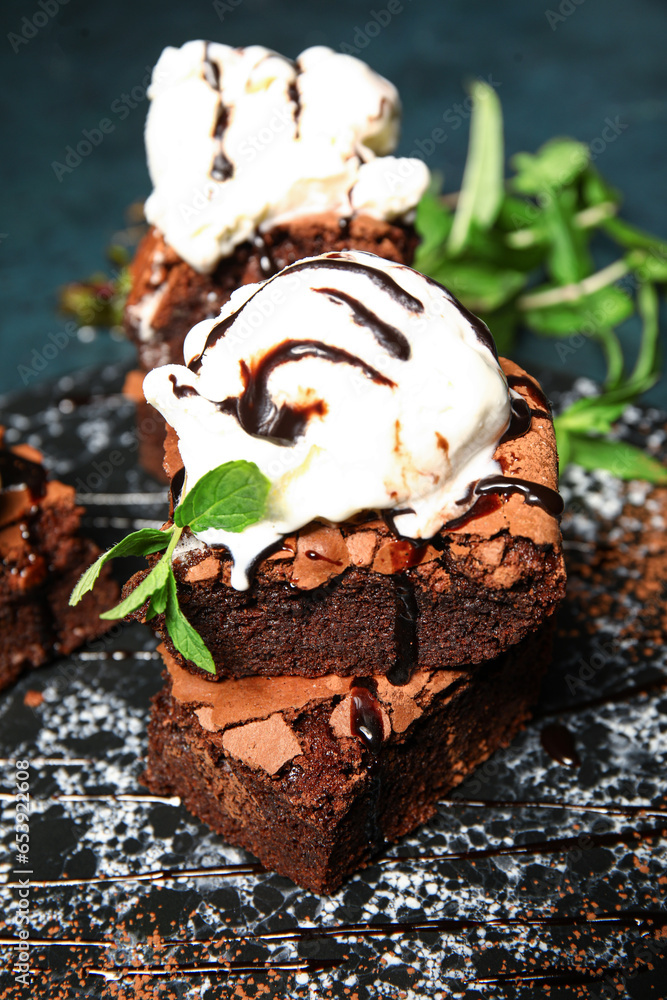 Board with pieces of tasty chocolate brownie and ice cream on table