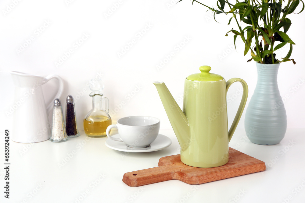 Composition with teapot, cup and different items on white table