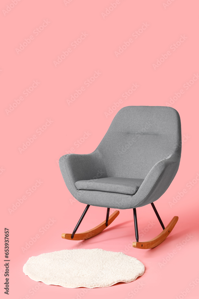 Rocking chair with rug on pink background