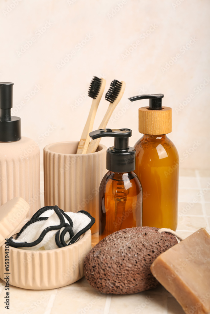 Set of cosmetic products and bath supplies on light tile table, closeup