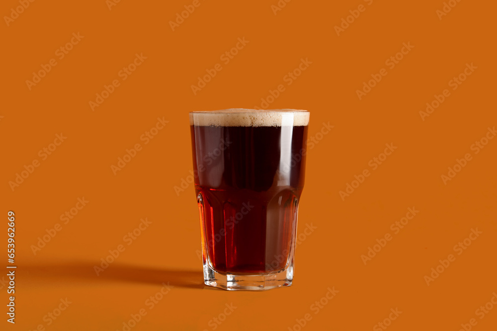 Glass of tasty kvass on orange background