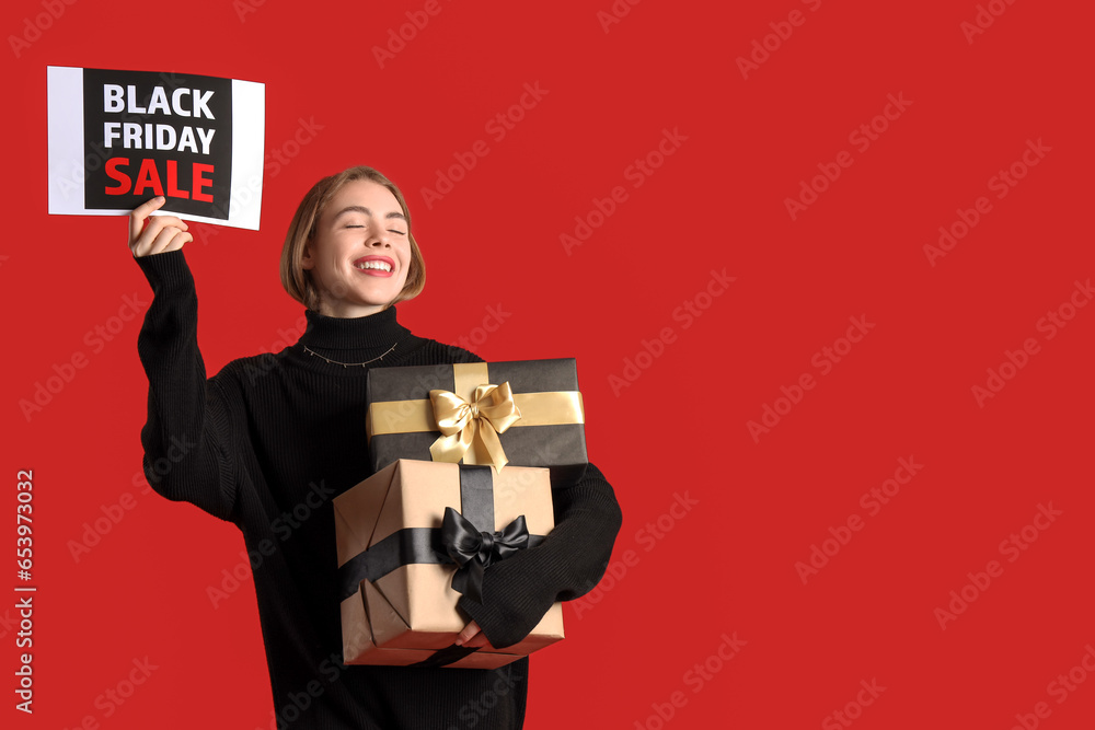 Young woman with card and gifts on red background. Black Friday sale