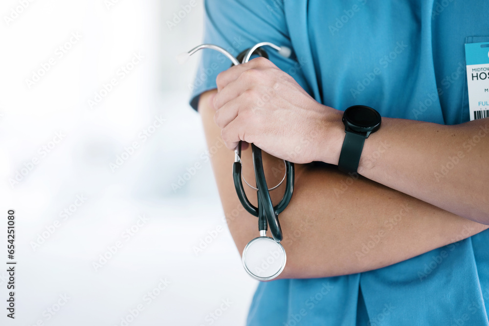 Closeup, hands of surgeon and arms crossed with stethoscope in hospital, surgery or clinic mockup. Cardiology doctor with medical tools of consulting, healthcare services or cardiovascular evaluation