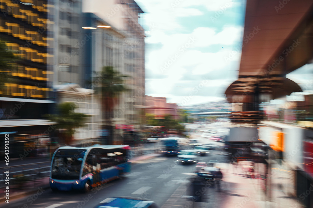 Busy city, road and cars in motion blur for morning traffic, travel and transportation in CBD. Urban commute, office building and street with bus stop, people on sidewalk and fast journey to work.