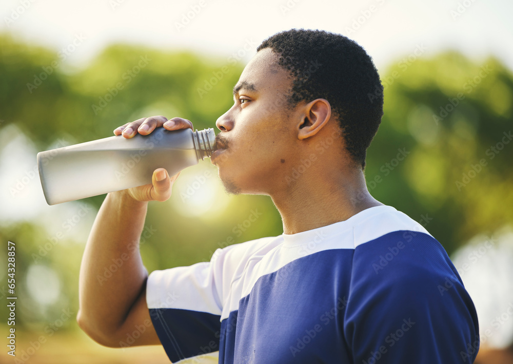 Nature, relax or black man drinking water on break after exercise, workout or fitness training in park. Profile, healthy or thirsty African sports athlete with liquid bottle for wellness or hydration