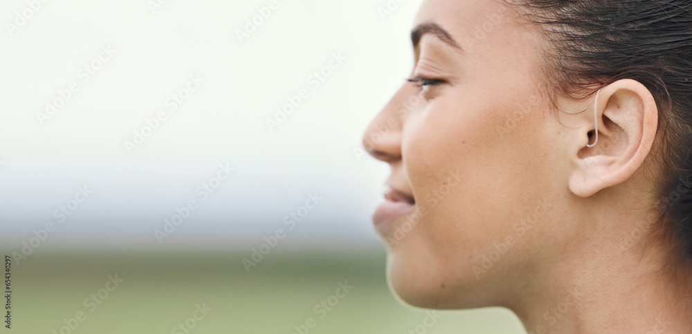 Face, mockup or hearing aid and a sports woman outdoor with an implant for sound or audio improvement. Profile, deaf and happy young athlete with an ear disability or impairment at training on space