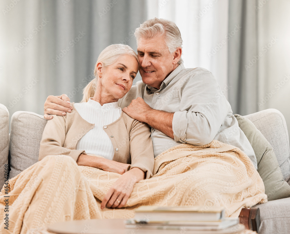 Senior couple, bonding and care on a living room sofa with hug and relax at home. Elderly people, bonding and marriage love in retirement with blanket and calm in a lounge on a couch together