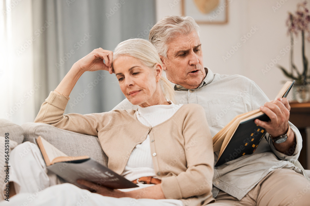 Old couple on sofa, reading book and relax together at home, retirement and wellness with love and comfort. Trust, care and support in marriage, share hobby with partner for knowledge and story