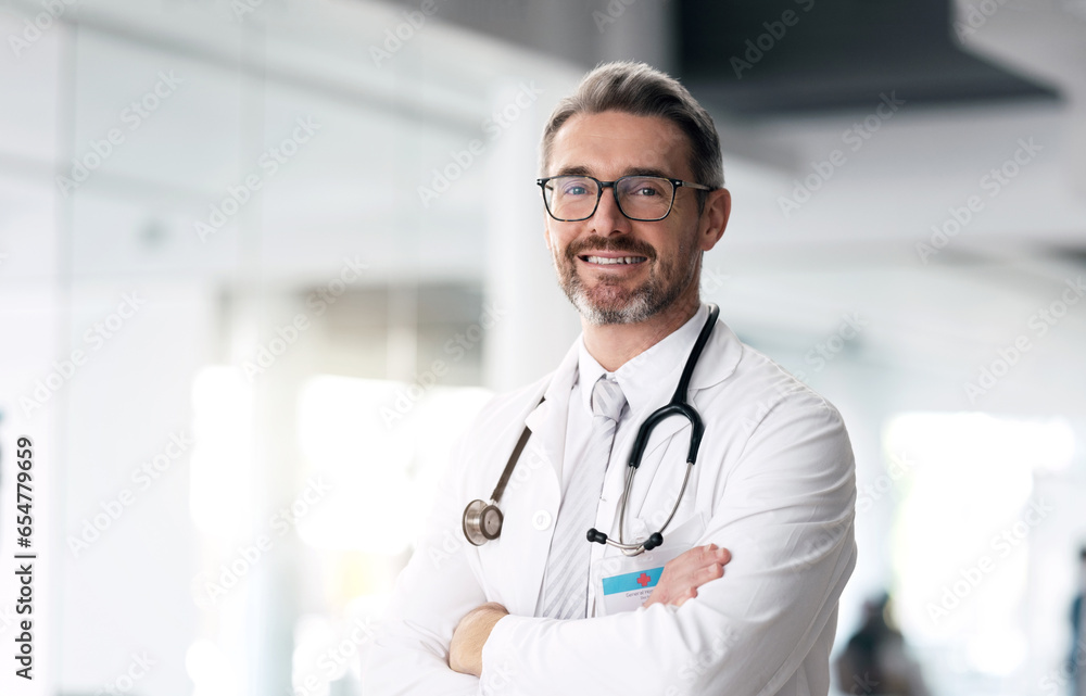 Happy doctor, portrait and man with arms crossed in hospital for healthcare, wellness or career. Face, medical professional smile and confident surgeon, expert or mature employee in glasses in Canada