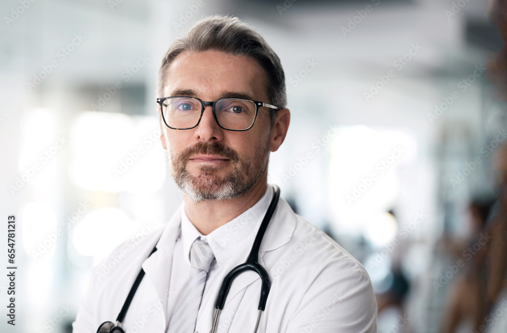 Serious doctor, portrait and man with glasses in hospital for health, wellness or career in medicine. Face, medical professional and confident surgeon, expert therapist or mature physician in Canada