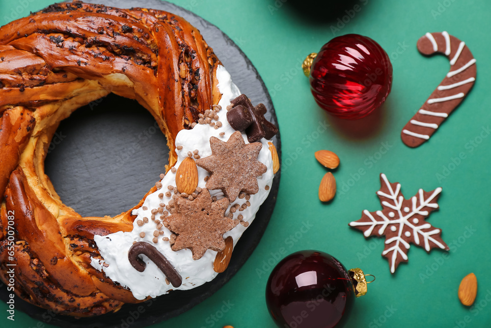 Board with tasty Christmas pastry wreath, cookies and balls on color background, closeup