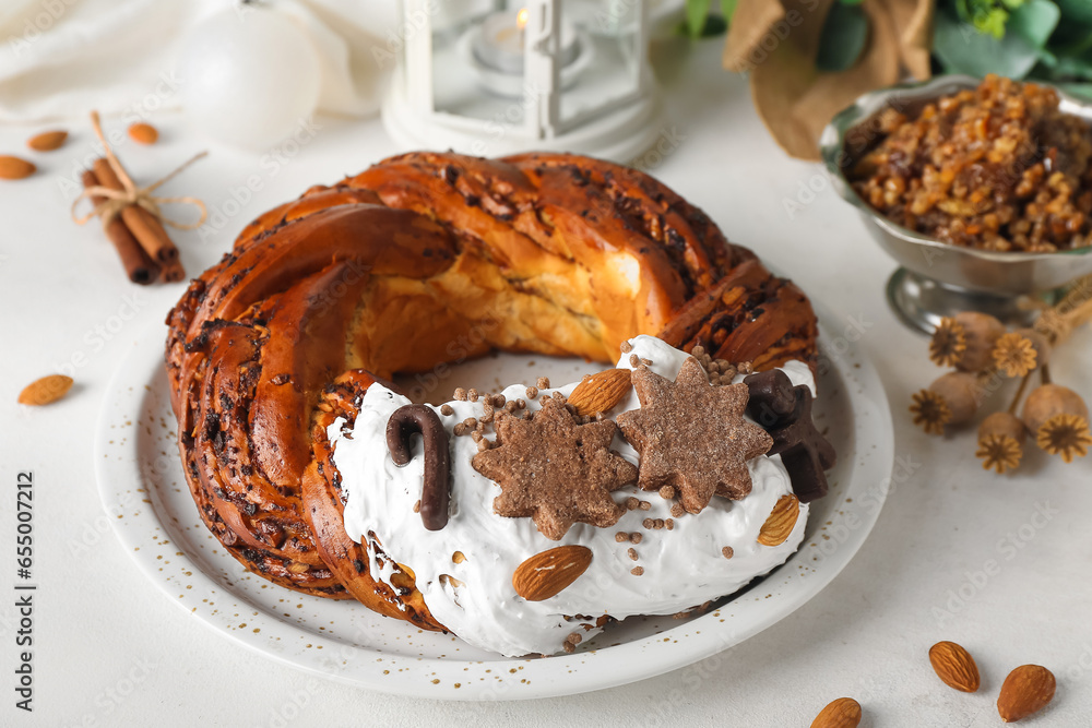 Plate with tasty Christmas pastry wreath and Kutya on light background