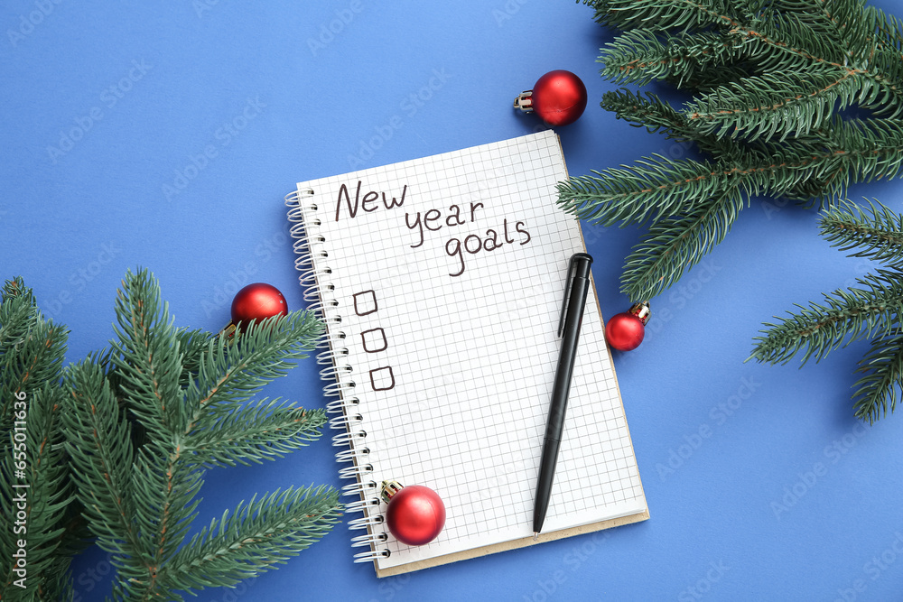 Notebook with empty to do list, Christmas balls and fir branches on blue background