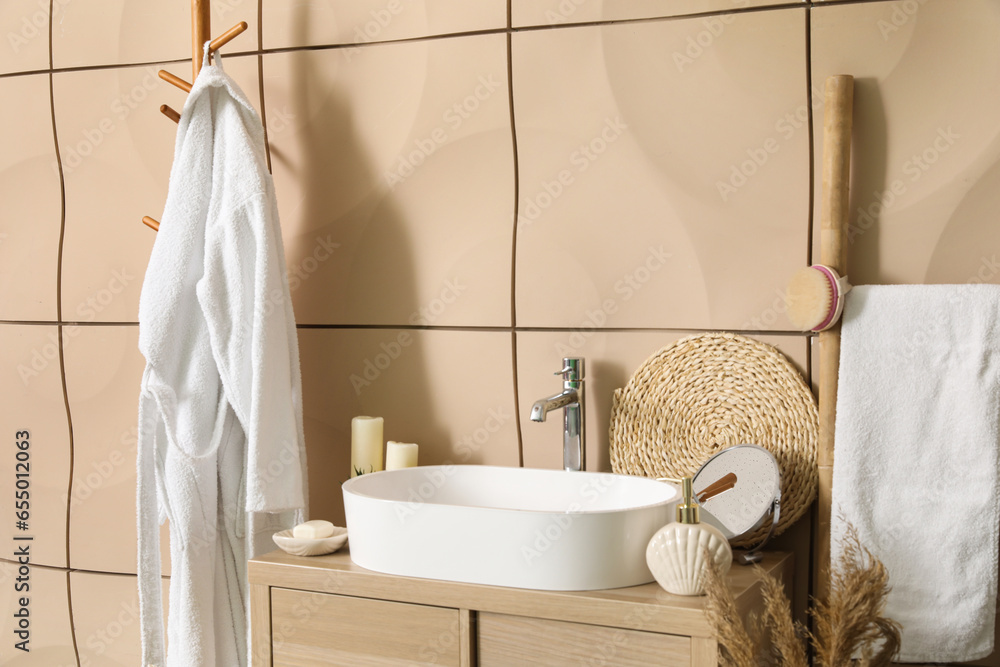 Sink bowl with bath accessories on table in bathroom