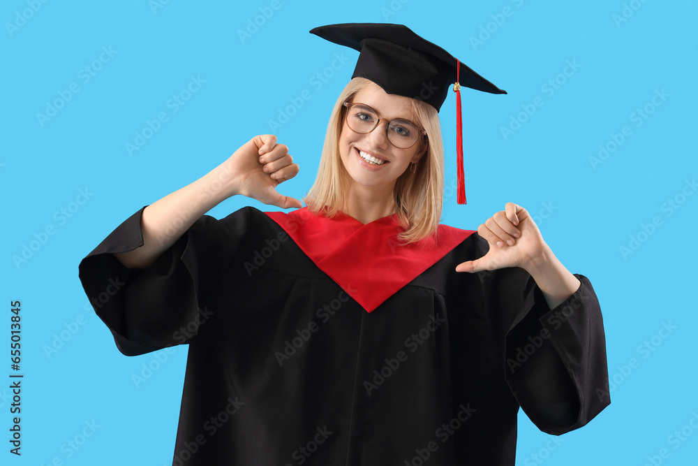 Female graduate student pointing at herself on blue background