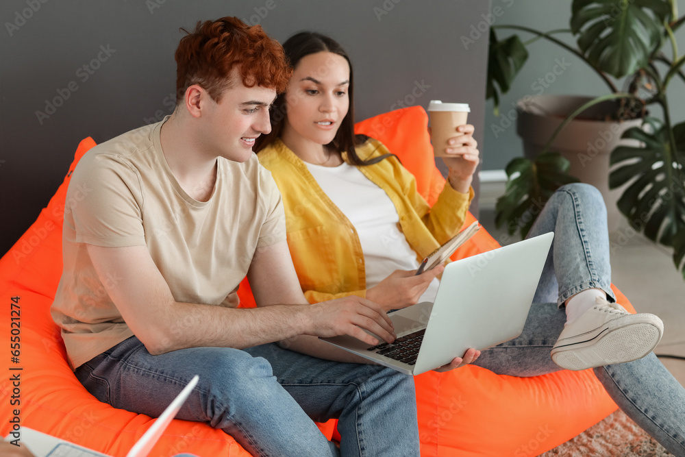 Young programmers working with laptop in office