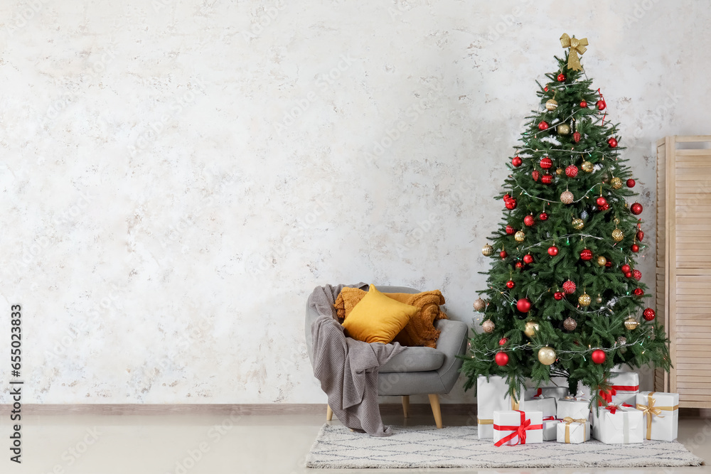 Interior of living room with grey armchair, Christmas tree and gift boxes