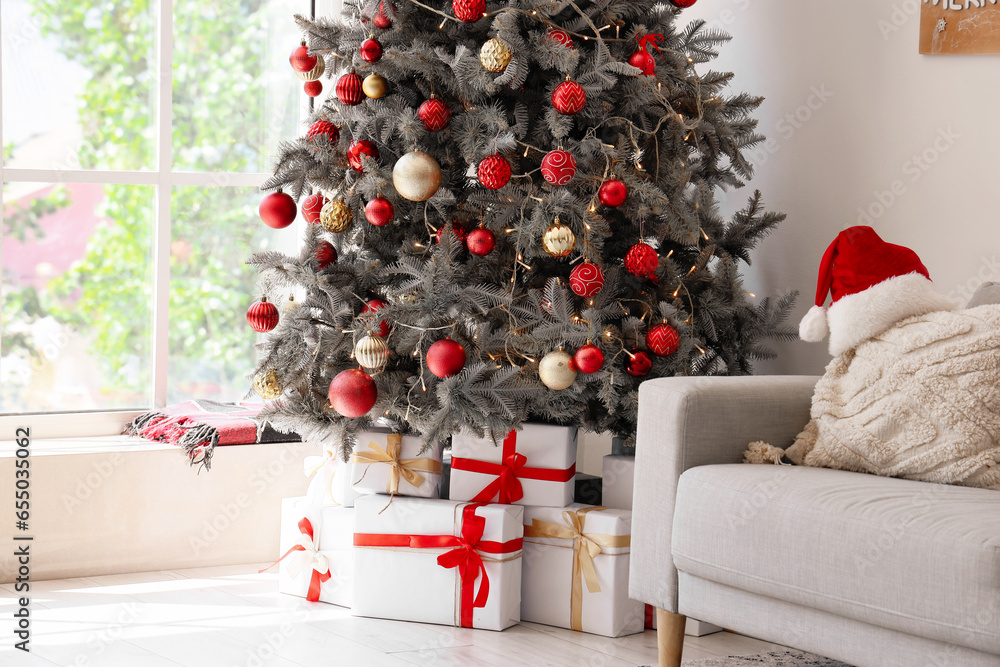 Gift boxes under Christmas tree in festive living room