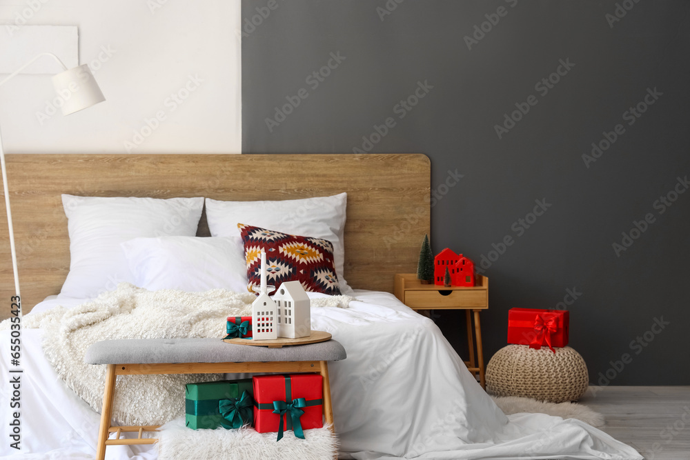 Interior of festive bedroom with comfortable bed and Christmas decor