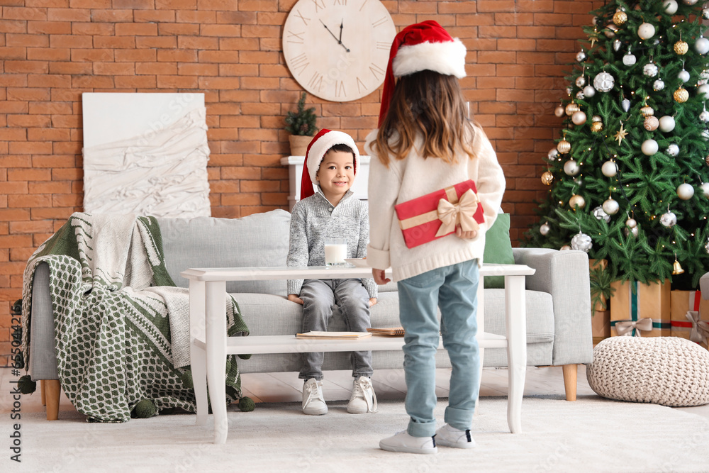 Little girl greeting her brother on Christmas at home