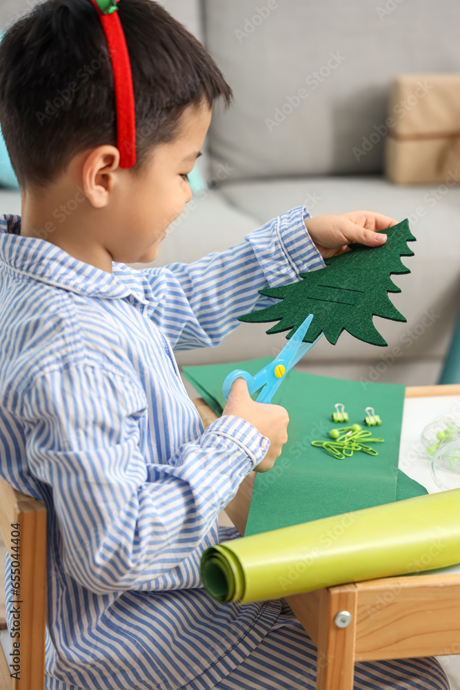 Cute little boy creating Christmas decor at home