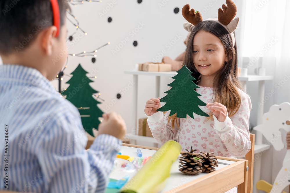 Cute little children creating Christmas decor at home