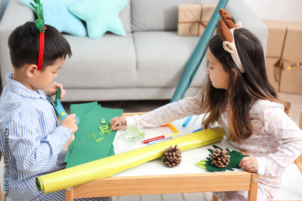 Cute little children creating Christmas decor at home