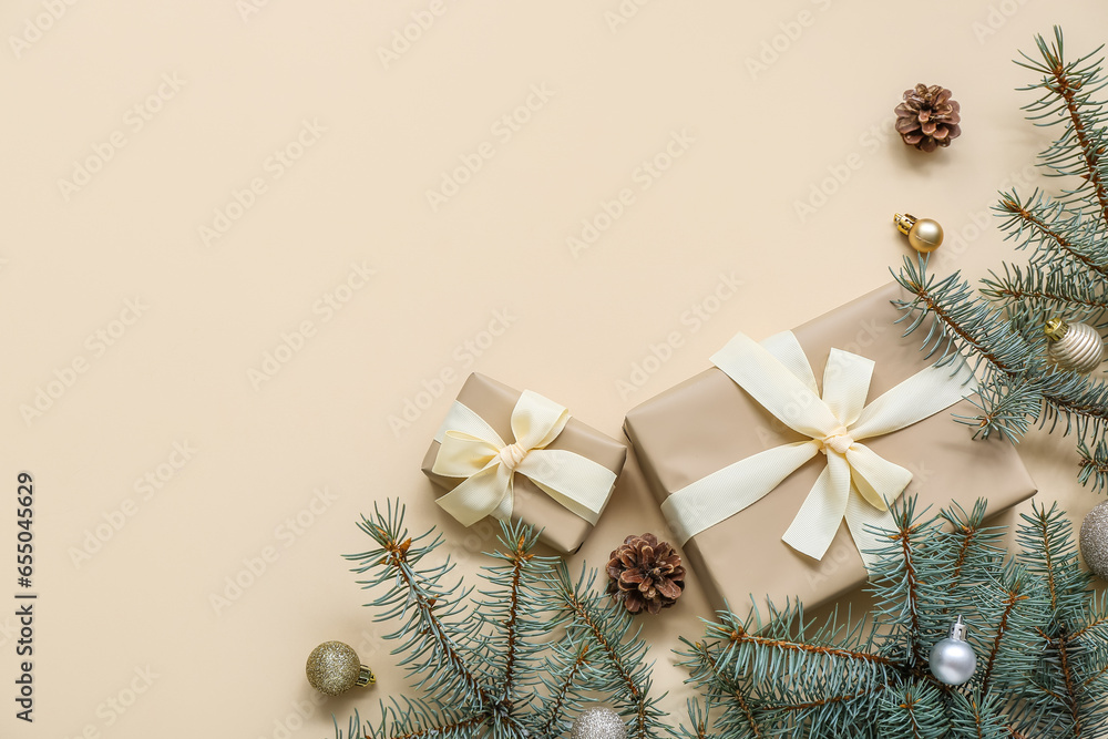 Christmas tree branches with balls and gift boxes on beige background