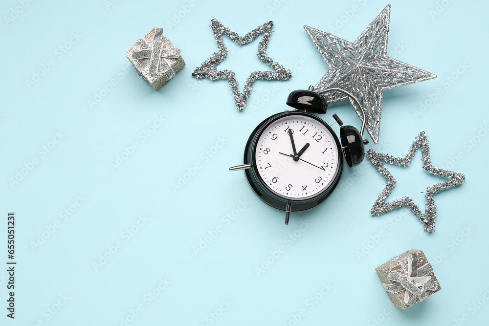 Composition with alarm clock, Christmas decorations and gift boxes on color background