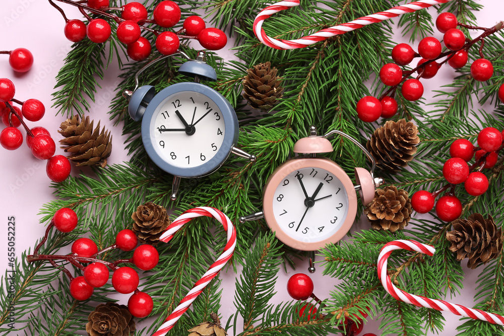 Alarm clock and candy canes, Christmas tree branches with rowan on lilac background