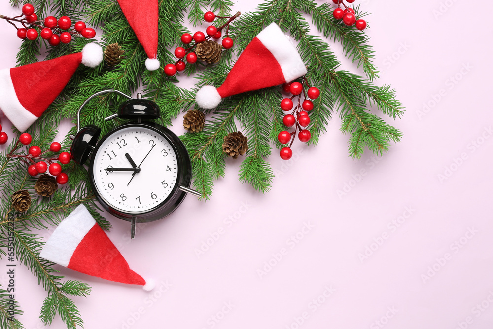 Alarm clock and Santa hats, Christmas tree branches with rowan on lilac background