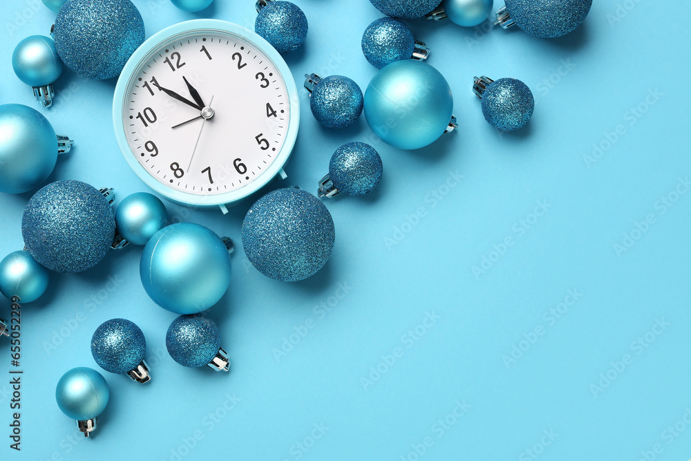 Alarm clock with Christmas balls on blue background