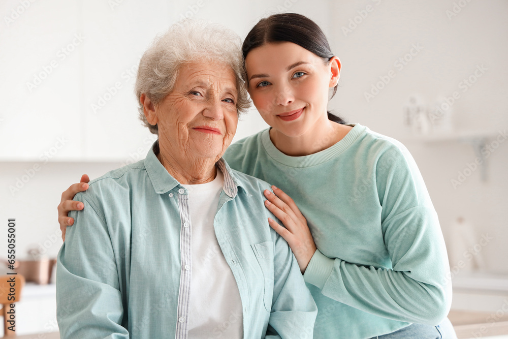 Senior woman with her daughter hugging in kitchen