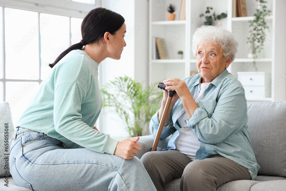 Upset senior woman with her displeased daughter at home