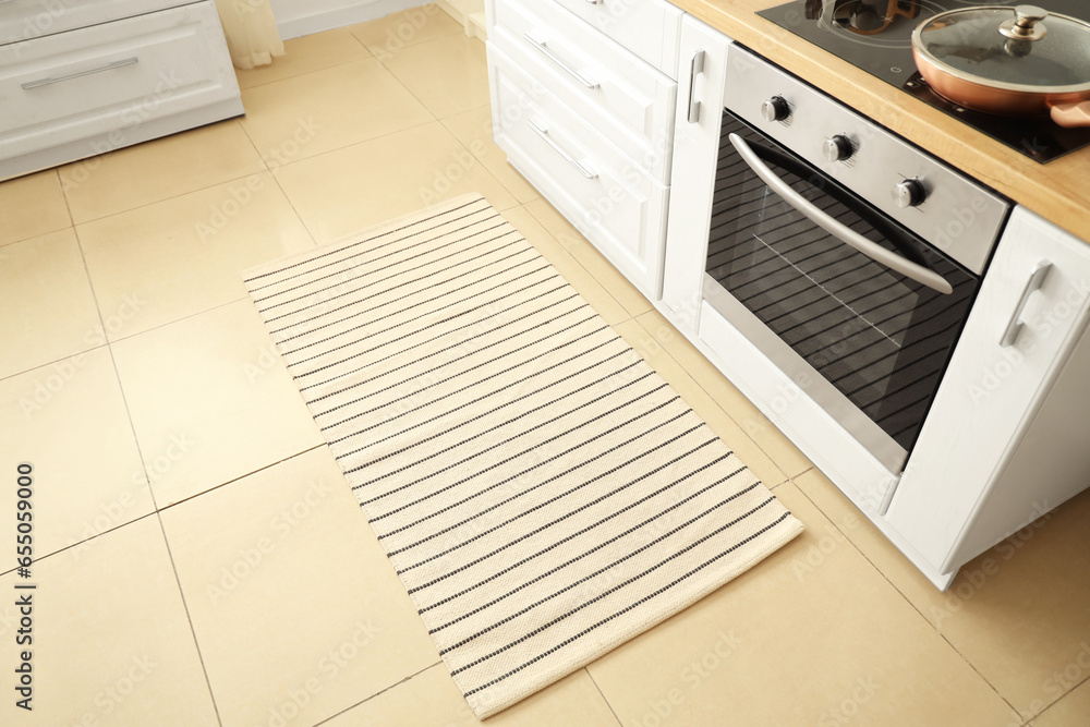 Interior of light kitchen with striped carpet