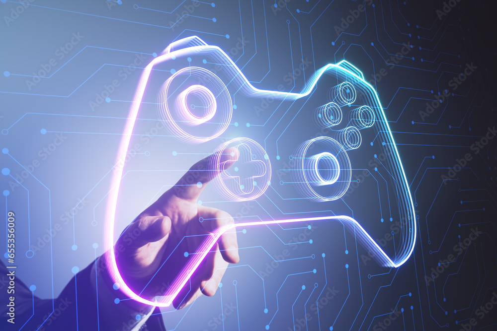 Close up of man hand pointing at creative joystick or gamepad hologram on blurry background. Esport, gaming and fun concept.