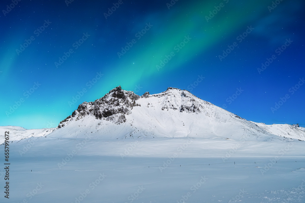 Aurora Borealis. Northern lights and clear skies. Nature. Scandinavian countries. Snow and ice on the mountains. Landscape in winter time. Photo for background and wallpaper.