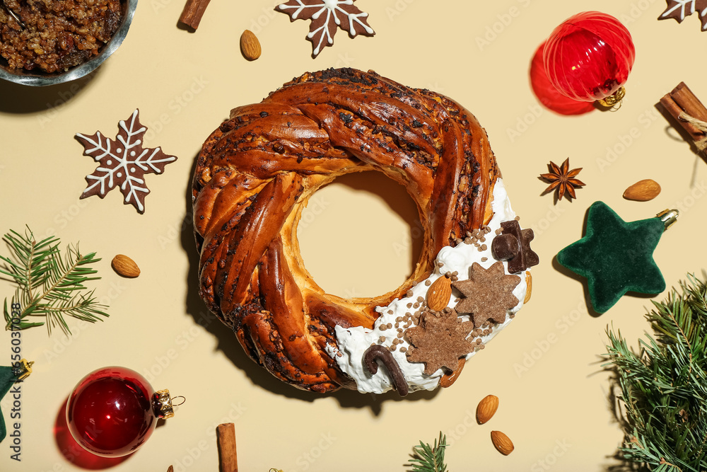 Tasty Christmas pastry wreath, cookies, decorations and spices on color background