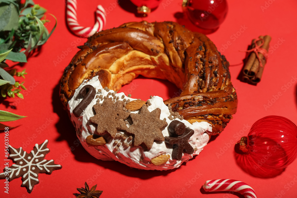 Tasty Christmas pastry wreath and decorations on red background