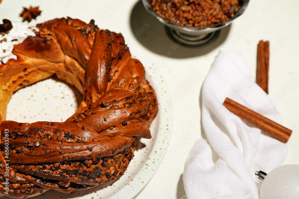 Plate with tasty Christmas pastry wreath on light background, closeup