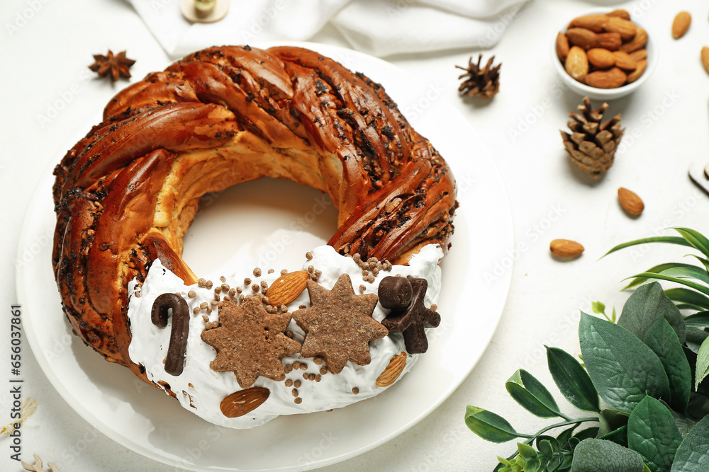 Plate with tasty Christmas pastry wreath on light background, closeup