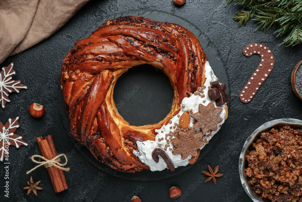 Composition with tasty Christmas pastry wreath, kutya, cookies and spices on dark background