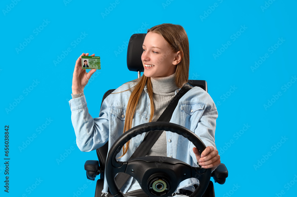 Female student with driving licence and steering wheel in car seat on blue background